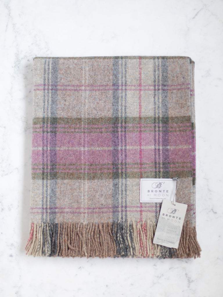 Shetland Quality throw, a mixture of grey, pink, blue, and green in a plaid pattern.