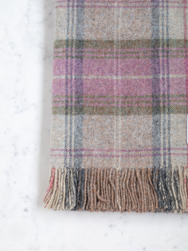 Shetland Quality throw, a mixture of grey, pink, blue, and green in a plaid pattern.