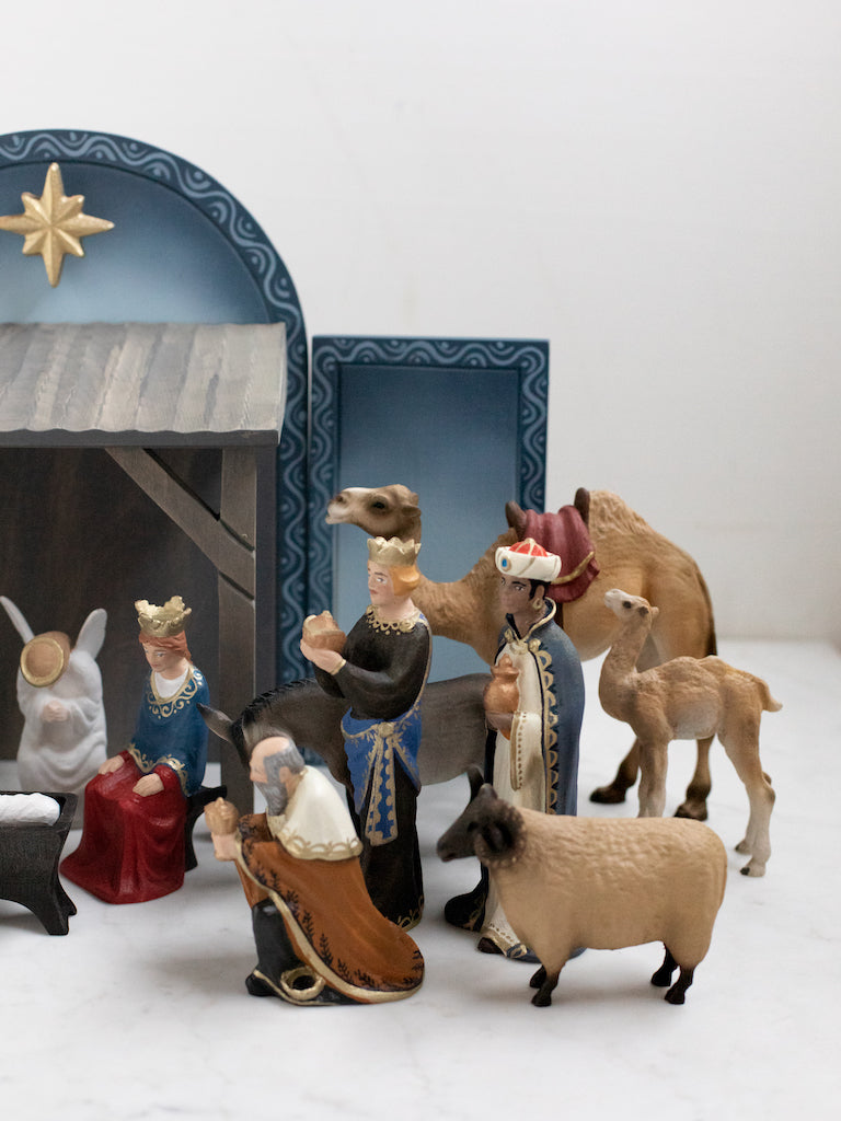 The three kings figurines along with a large camel and other animals.