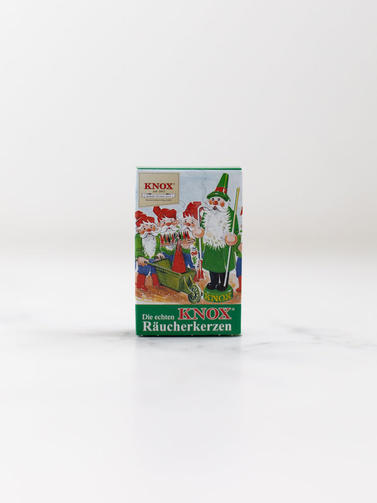 A box cover of an incense cone scent with a Christmas inspired character and three smaller versions of the character working together.