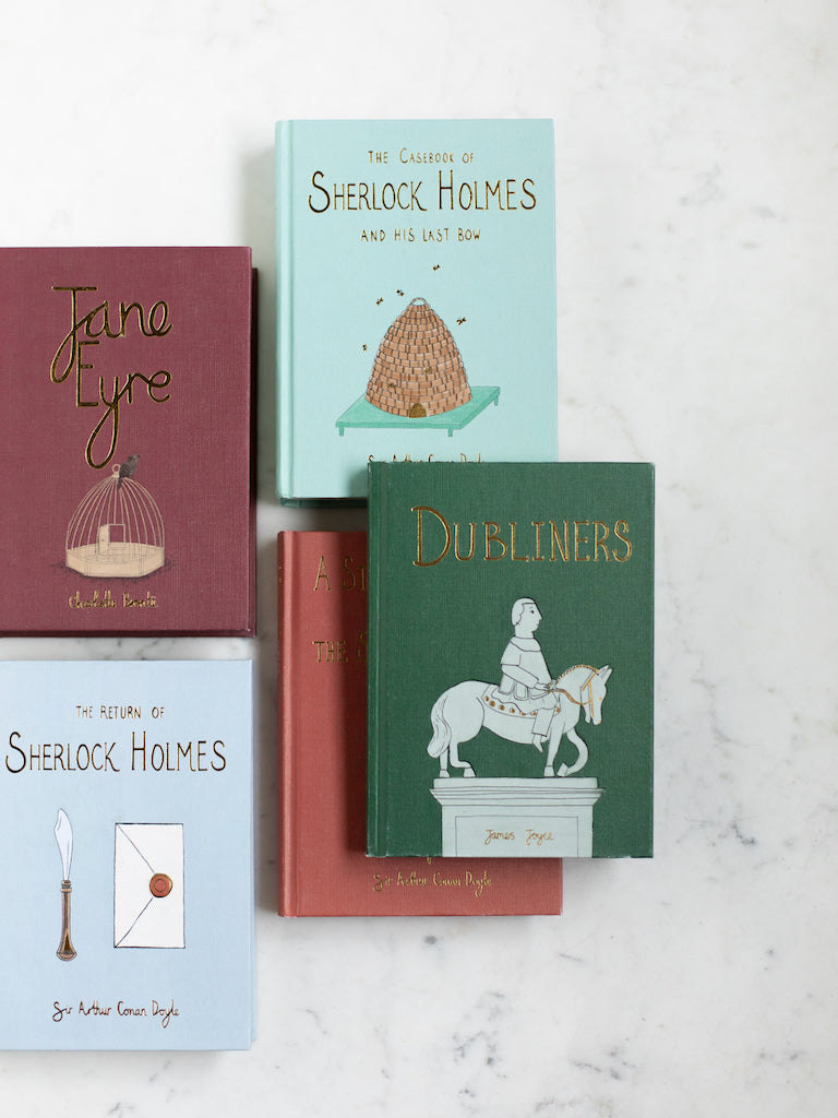 Various hardcover Wordsworth Edition Classic books on a white marble table.