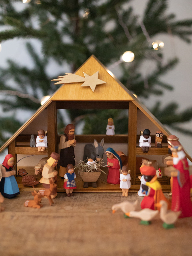 A nativity scene with all included characters under a manger.