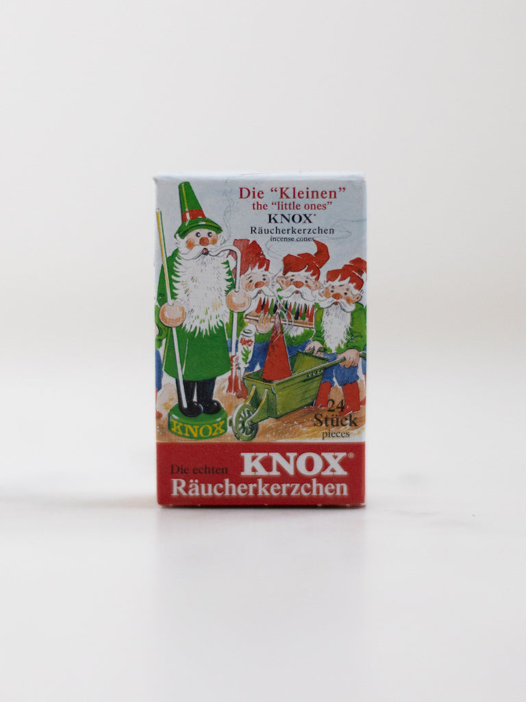 A box cover of an incense cone scent with a Christmas inspired character and three smaller versions of the character working together.