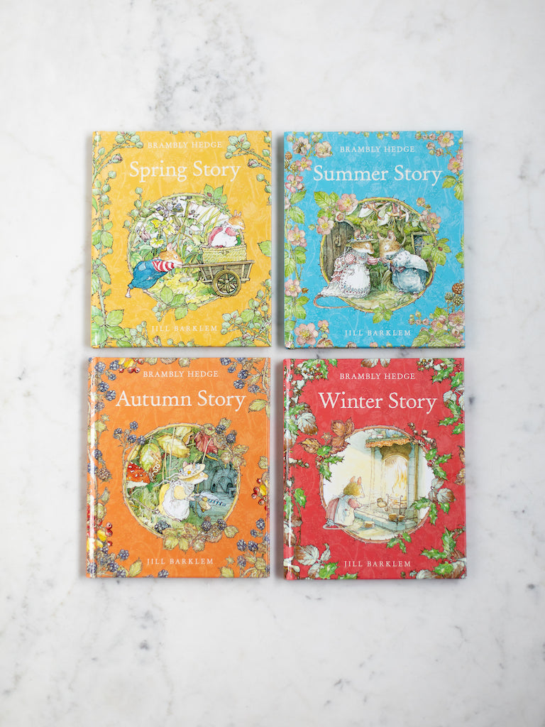 All four Brambly hedge season books laid out next to each other on a white counter.