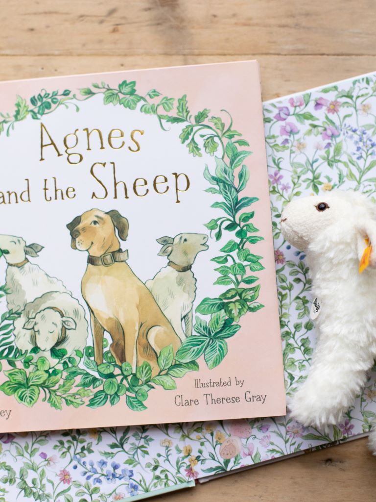 Alternate view of “Agnes and the Sheep” with sheep plushie.
