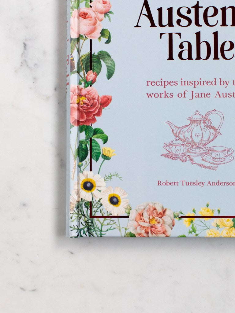 A close up photo of the vintage inspired flowers on a blue cookbook. 