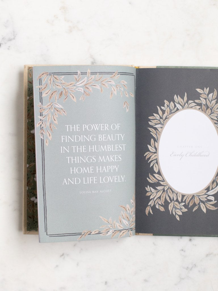 A book opened to a page with a quote from Louisa May Alcott saying “The power of finding beauty in the humblest things makes home happy and life lovely.”