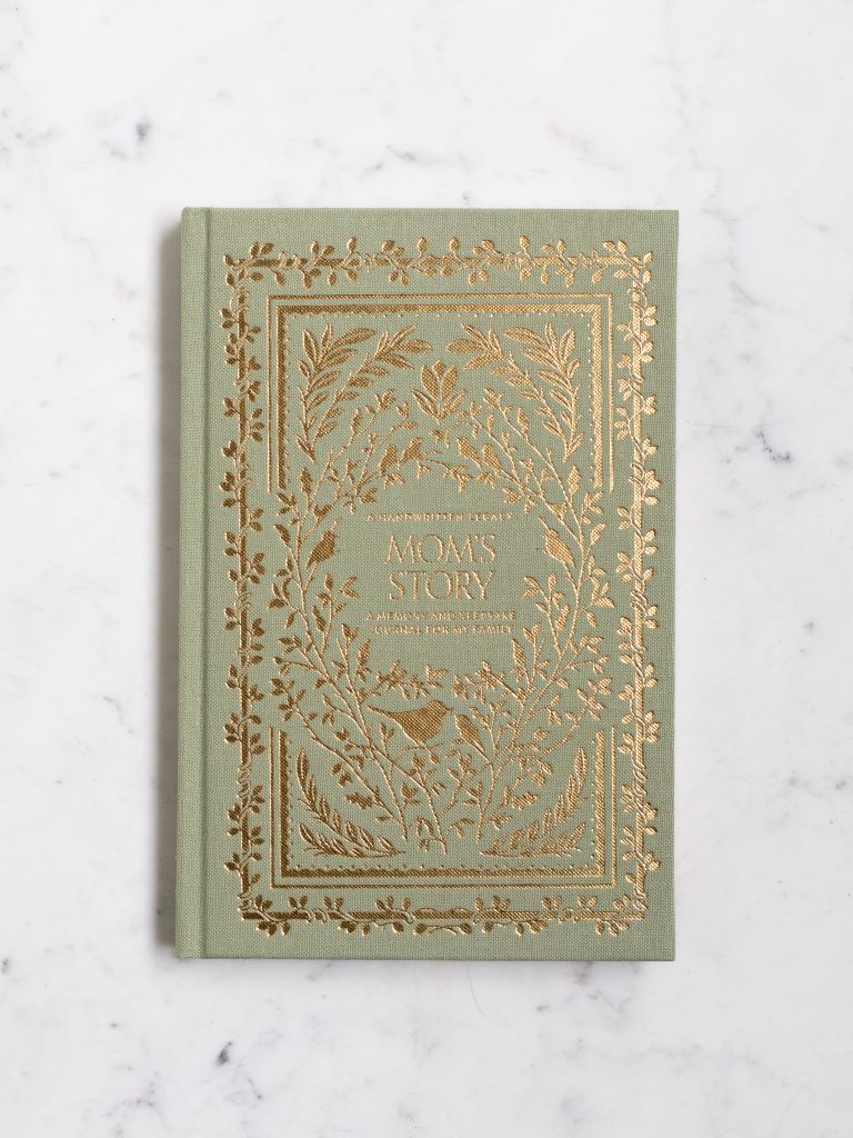 A green clothbound book with gold designs of birds and plants around the title “Mom’s Story.” 