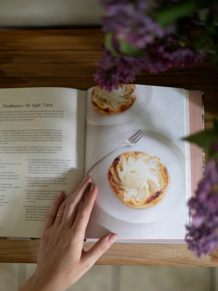 A cookbook opened to a recipe for an apple tart.