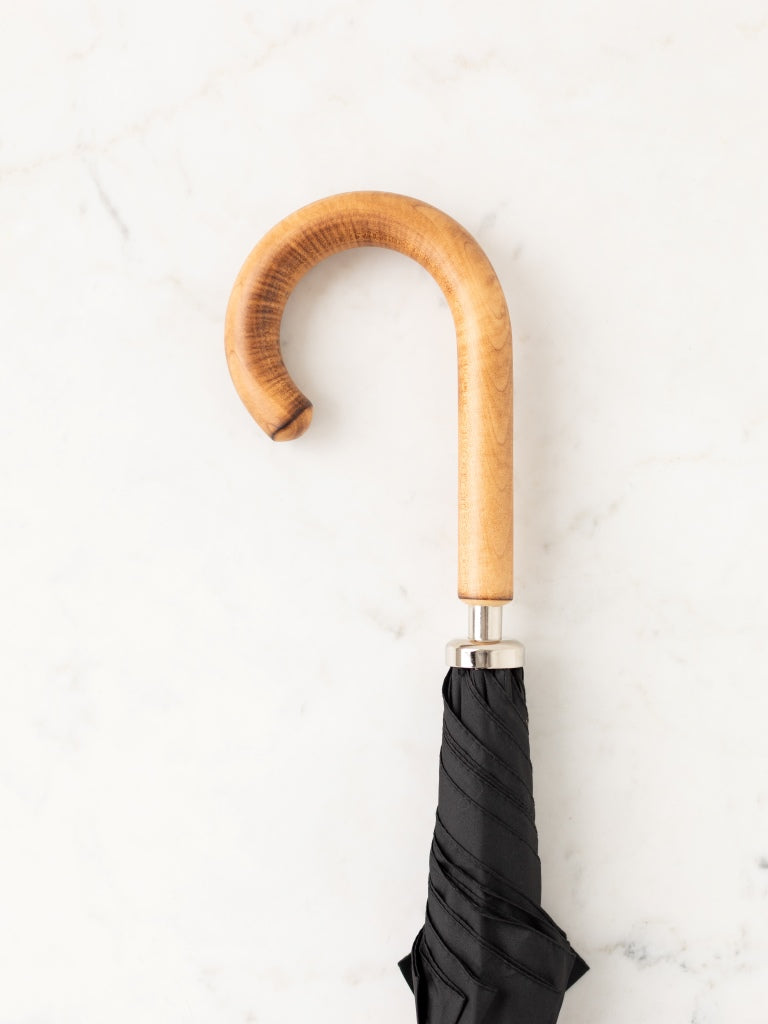 A wooden oak curved umbrella handle.
