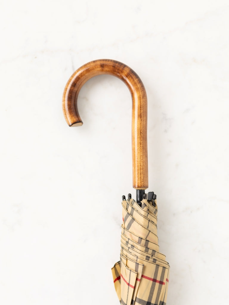 The oak curved wooden handle of an umbrella.