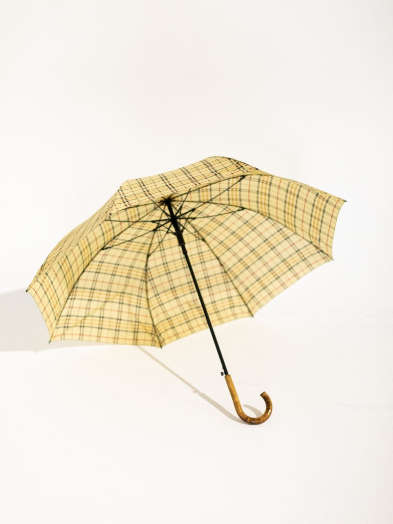The underside of an opened black and yellow checkered umbrella.