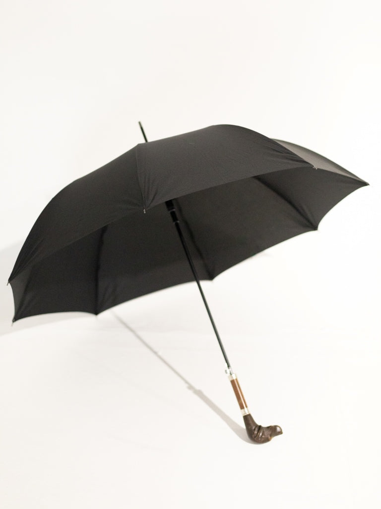 An opened black umbrella with a short dog head handle.