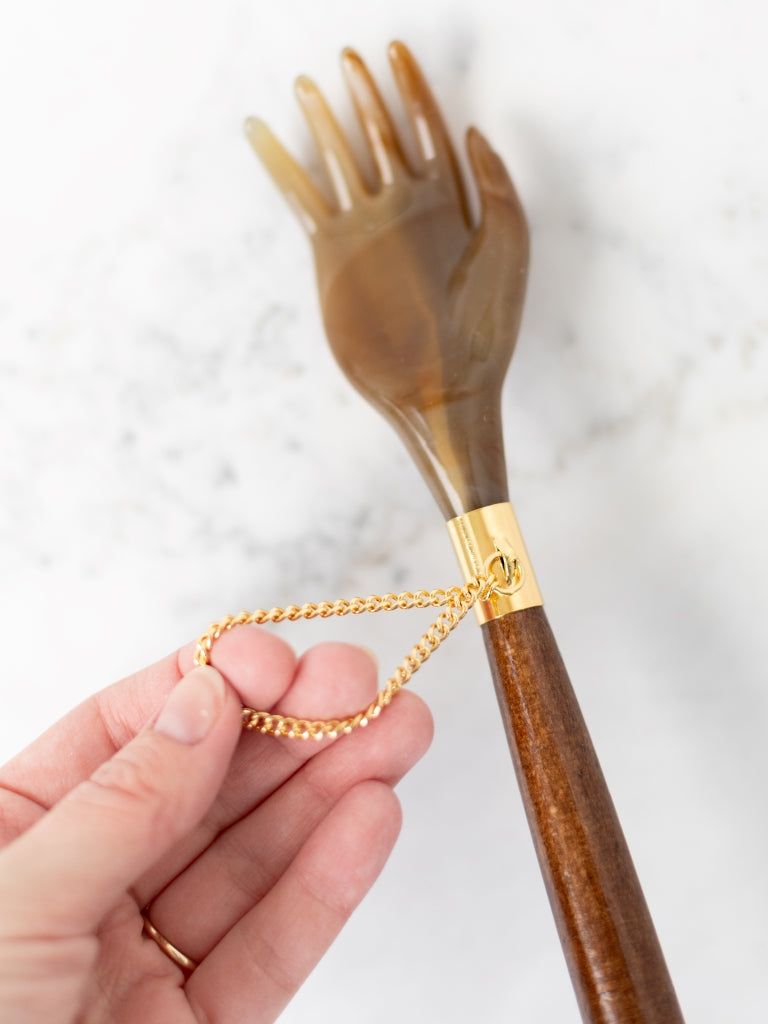 A closer view of the hand side of the back scratcher & shoe horn. It also shows the gold chain attached.