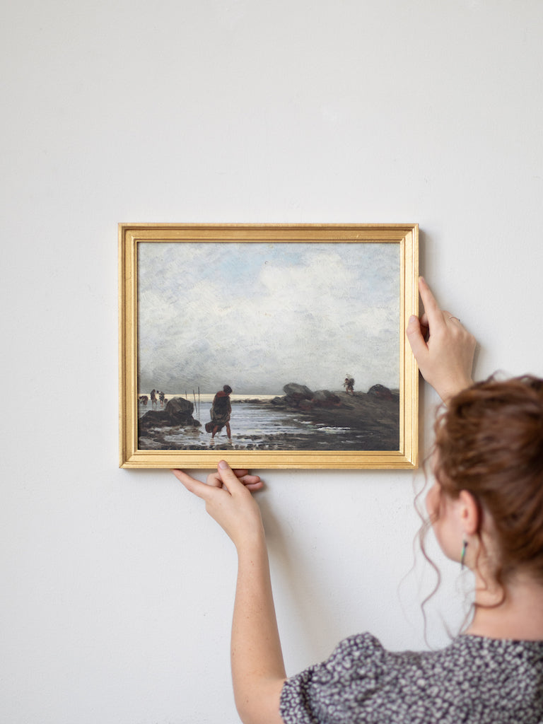 A woman hangs the medium sized framed print for scale. 