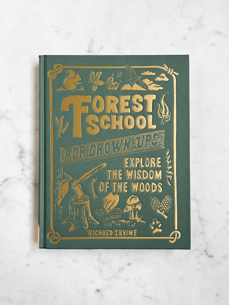 A green book with gold lettering titled “Forest School For Grown-ups” with a squirrel and a axe on the cover. 