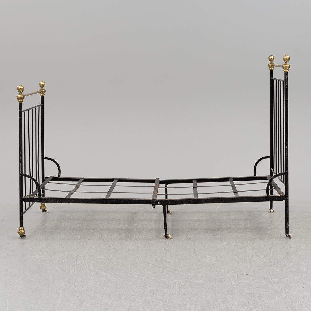 Black iron bed frame with brass bedknobs