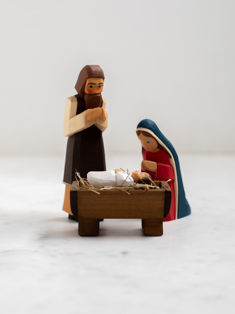 Wooden figurines of Joseph, Mary, and baby Jesus.