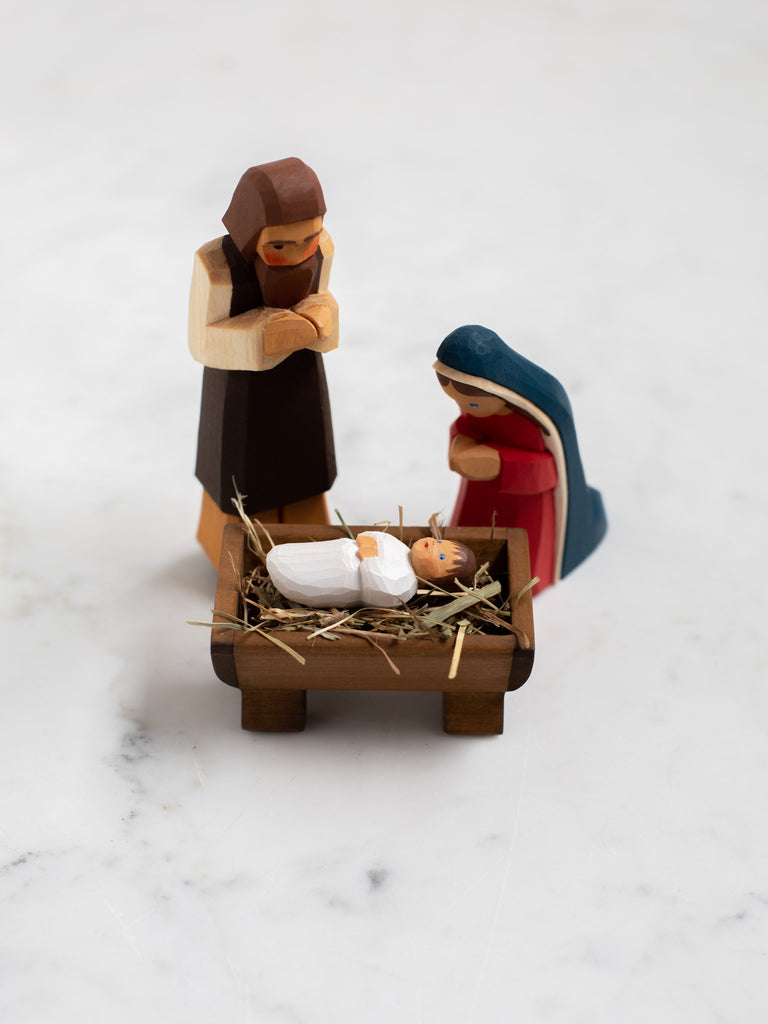 Wooden figurines of Joseph, Mary, and baby Jesus.