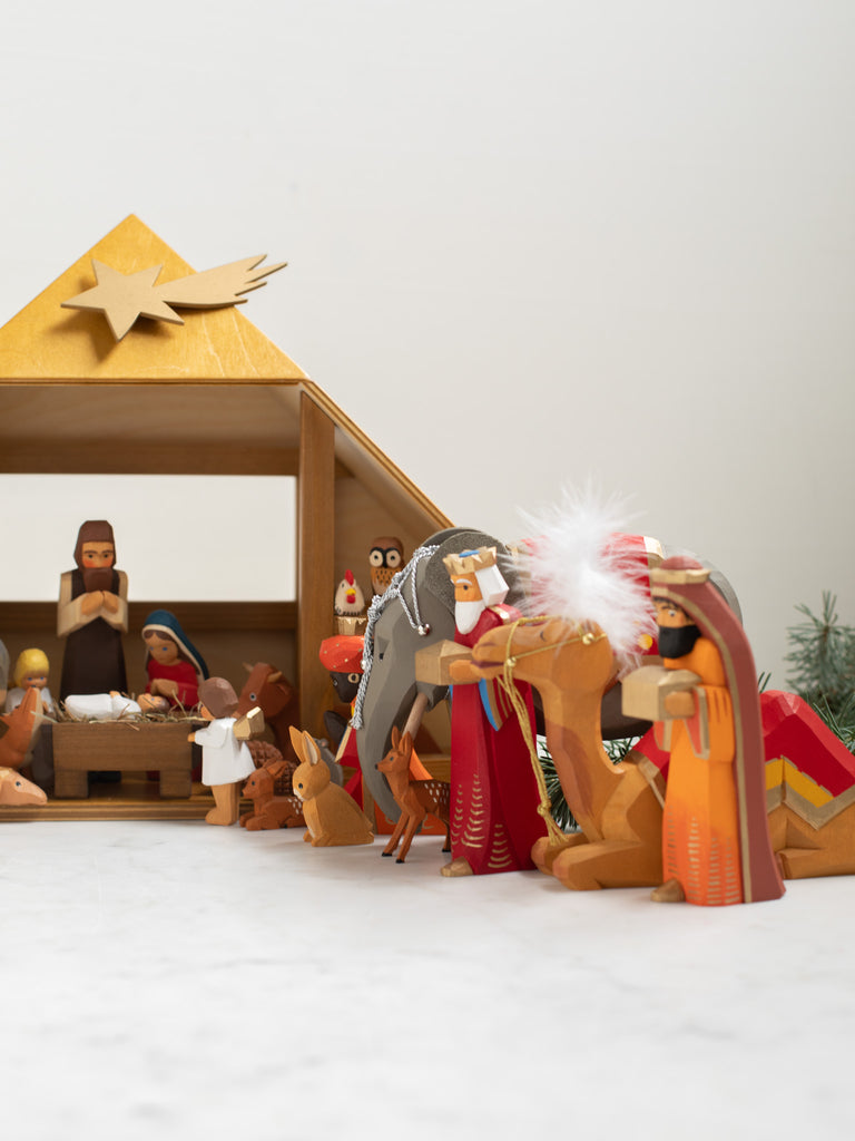 Multiple wooden human and animal figures kneeling and bowing.