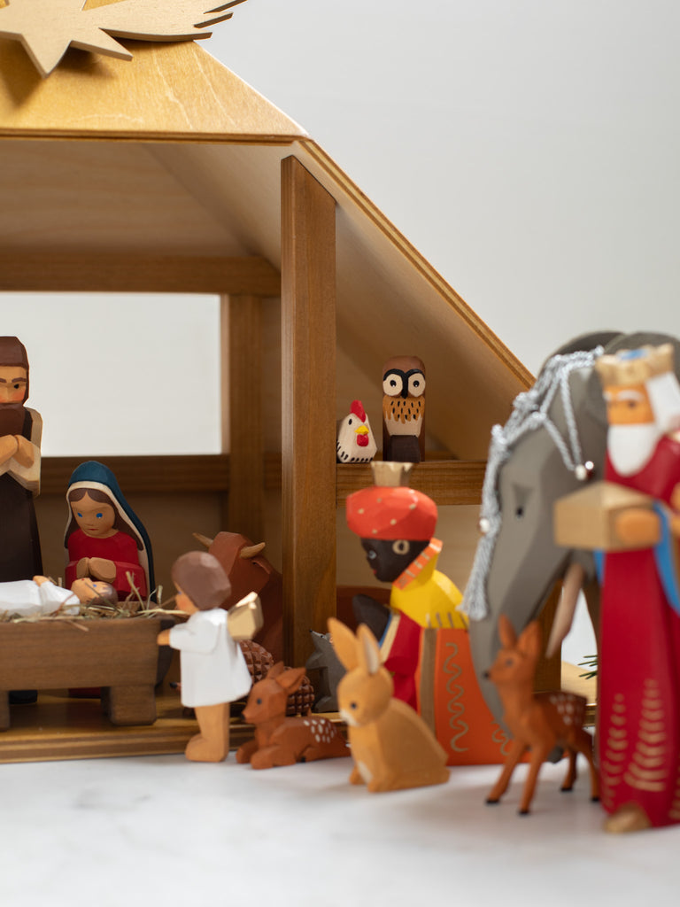 Multiple wooden human and animal figures kneeling and bowing.