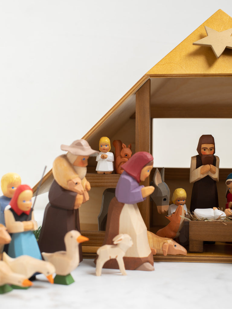 Multiple wooden human and animal figures kneeling and bowing.