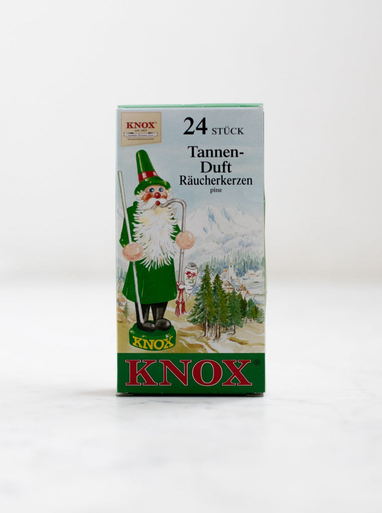 A box cover of an incense cone scent with a forest scene and a Christmas inspired character.