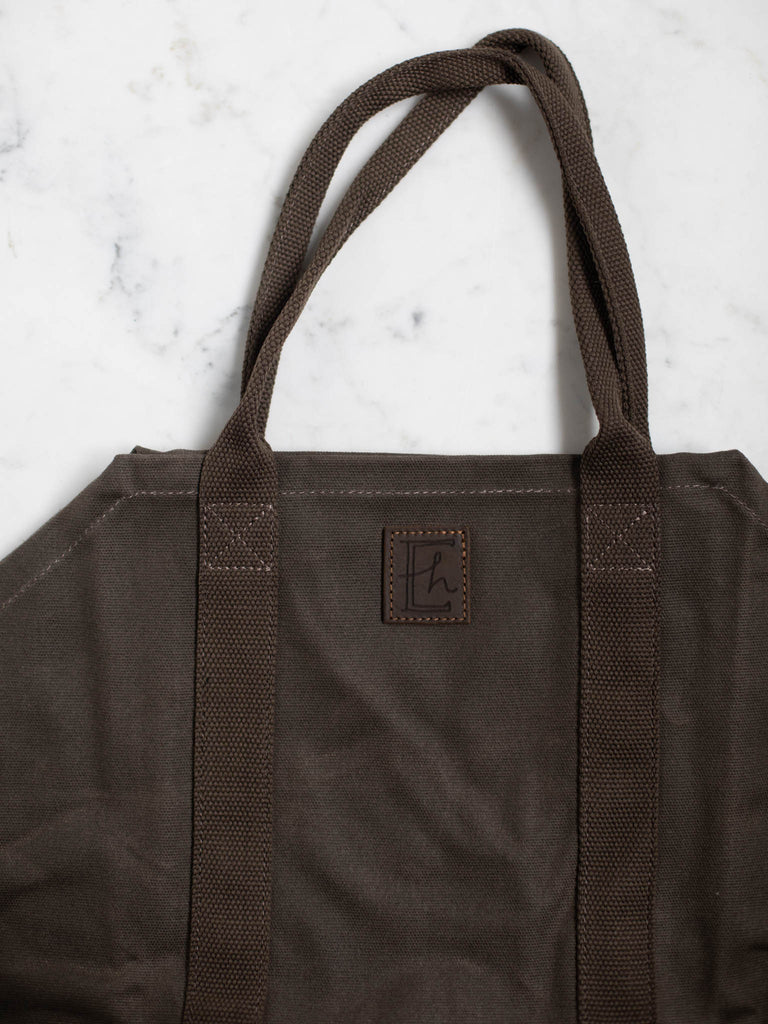 A close up of the canvas dark brown log carrier bag.