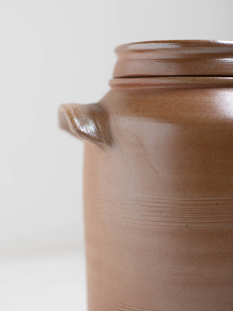 A handle on a light brown water jug.