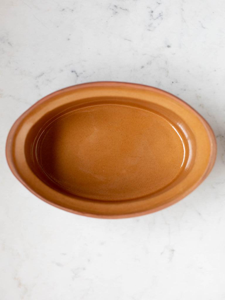 Light and dark brown casserole dish from the top showing light brown interior. 