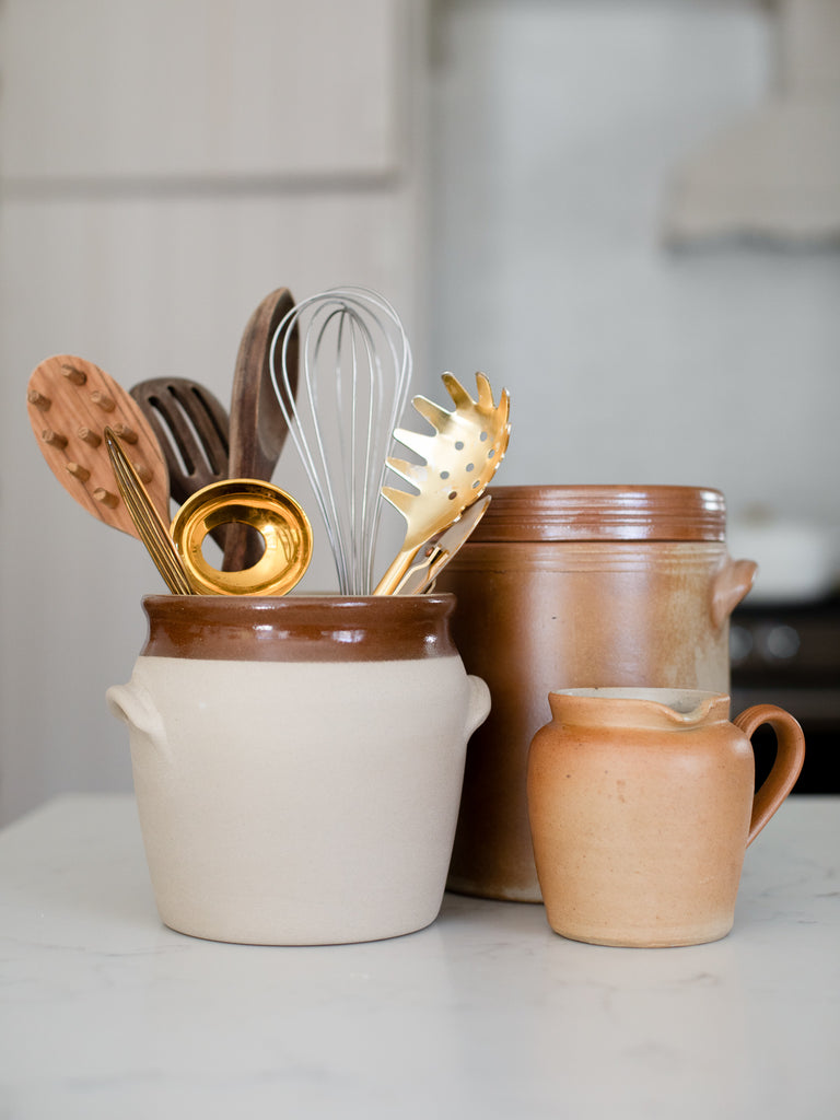 Various storage jars holding kitchen utensils. 