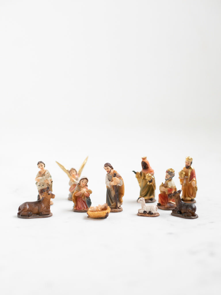 A miniature nativity set with intricately painted figures, serving as both art and table decoration.