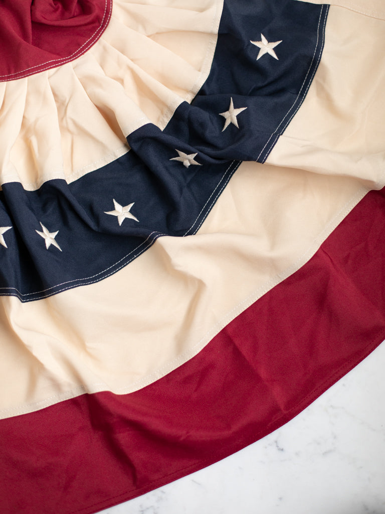 Close up of the Americana bunting flag, a rounded flag. The natural creases are shown on display.