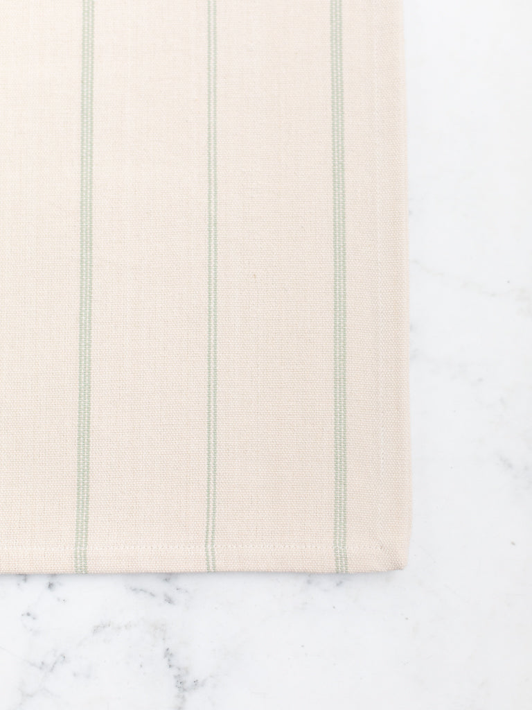 An off-white tablecloth with thin light green stripes.