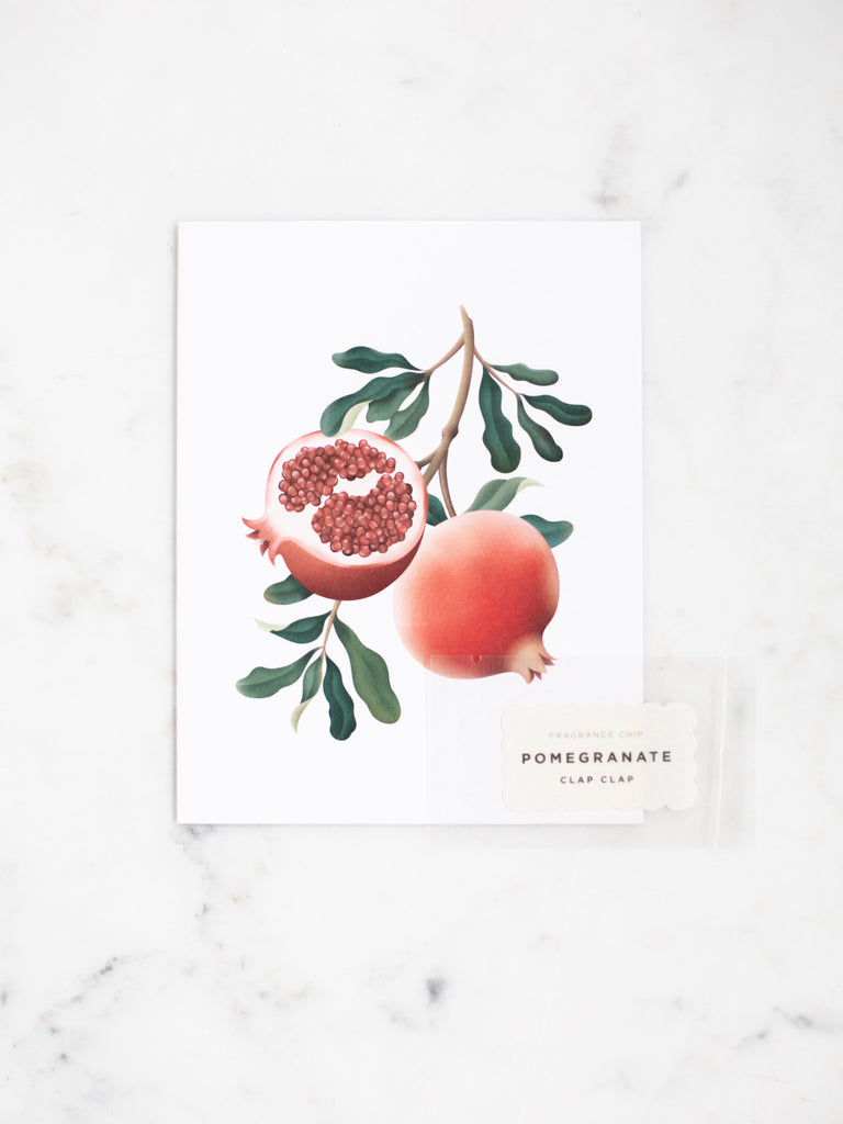 Red pomegranate botanical greeting card with dark green leaves.