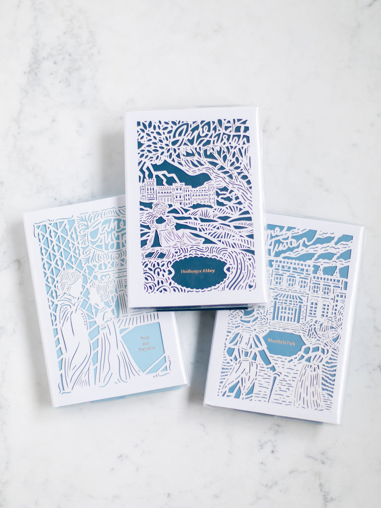 Three books with paper cut designs on the cover. 