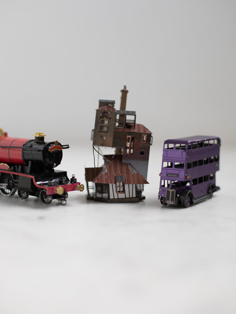 The train, house, and bus metal models placed next to each other.