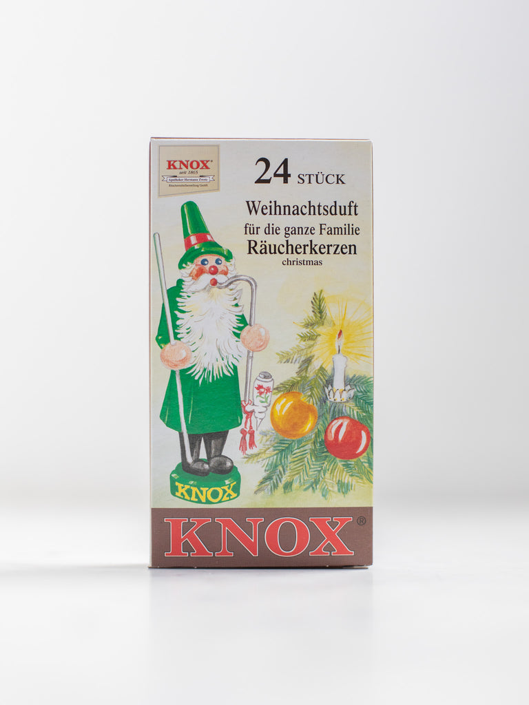 The box of an incense cone scent with a small Christmas tree and a Christmas style figurine.