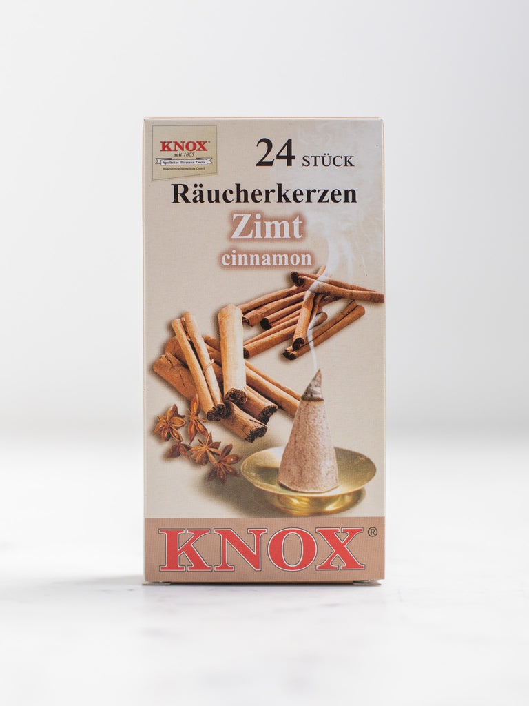 A box cover of an incense cone scent with pictures of multiple cinnamon sticks.