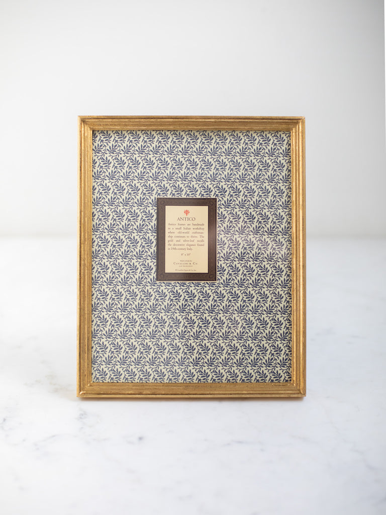 Vintage style gold frames, with a dark blue patterned paper held in the frame, with a description of where the frames are made.