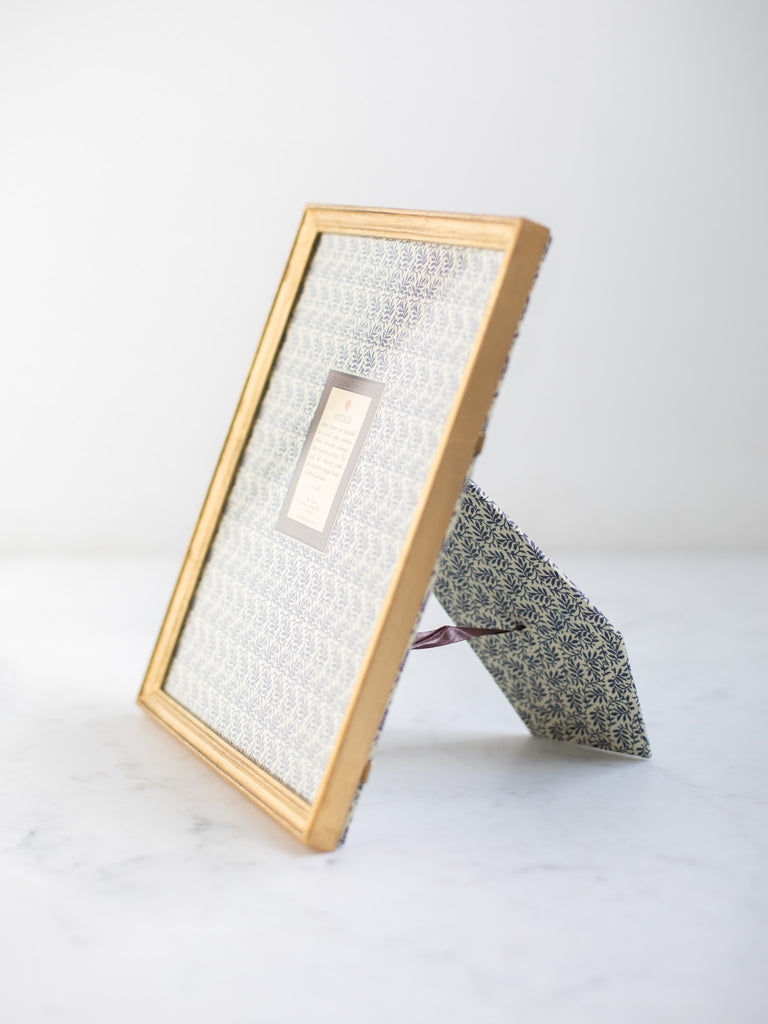 Vintage style gold frames, with a dark blue patterned paper held in the frame, with a description of where the frames are made.