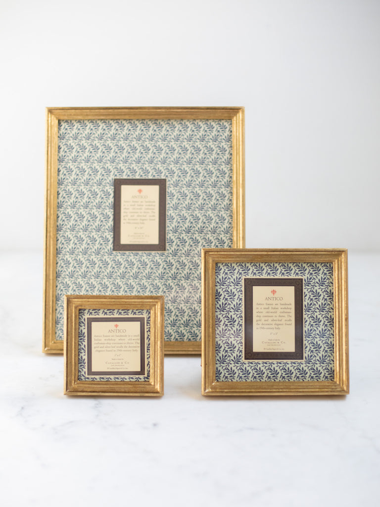 Vintage style gold frames, with a dark blue patterned paper held in the frame, with a description of where the frames are made.