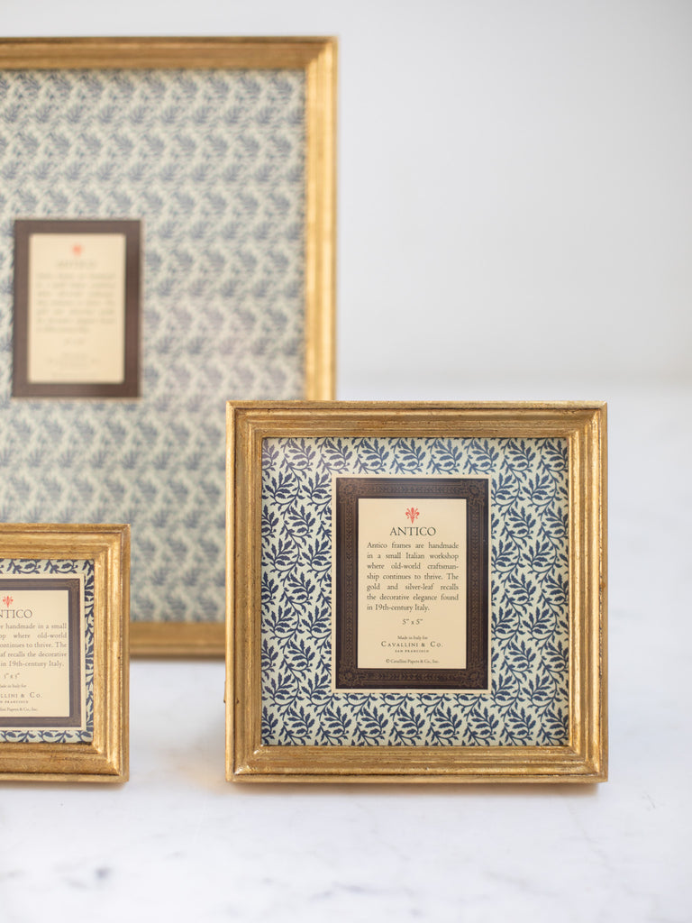 Vintage style gold frames, with a dark blue patterned paper held in the frame, with a description of where the frames are made.
