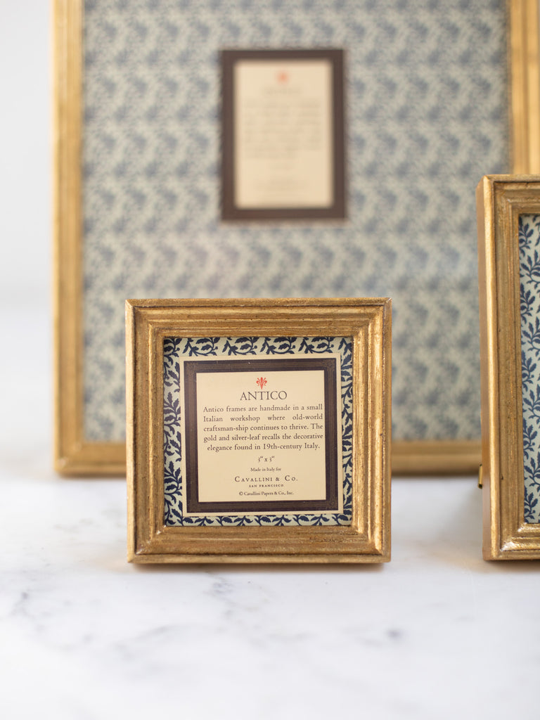 Vintage style gold frames, with a dark blue patterned paper held in the frame, with a description of where the frames are made.