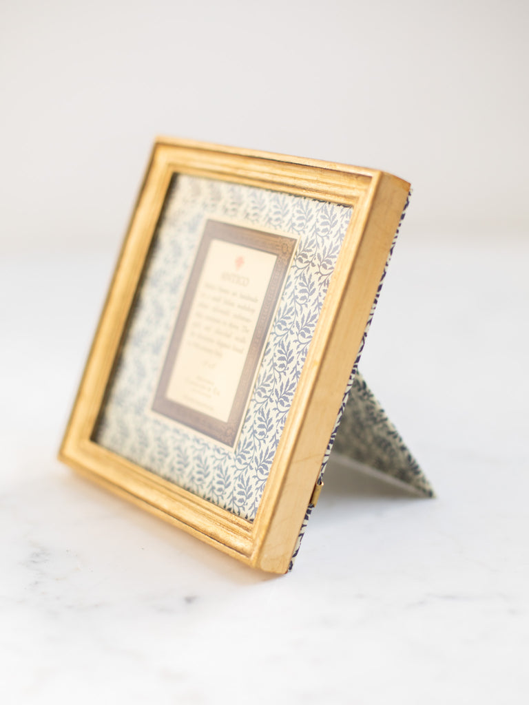 Vintage style gold frames, with a dark blue patterned paper held in the frame, with a description of where the frames are made.