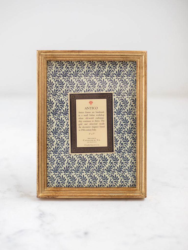 Vintage style gold frames, with a dark blue patterned paper held in the frame, with a description of where the frames are made.