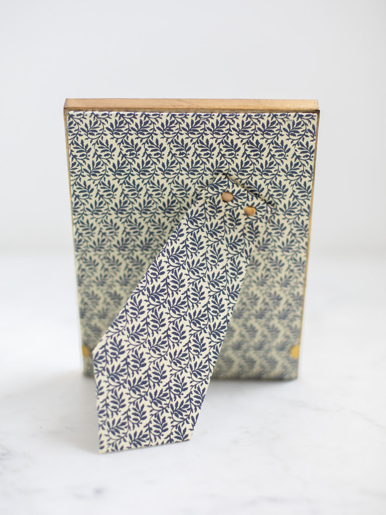 The back of the gold frames, a dark blue leaf batter covering the back of the frame and its stand.