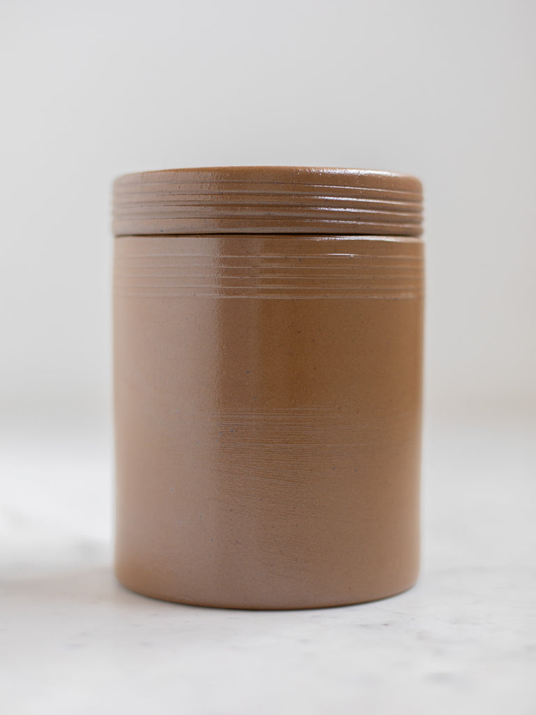 Brown condiment jar with a lid. 