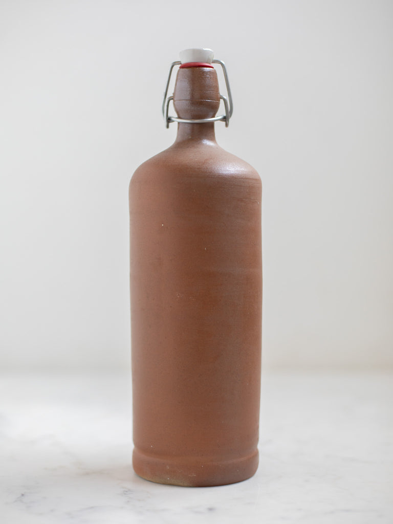 A tall light brown stone bottle. 