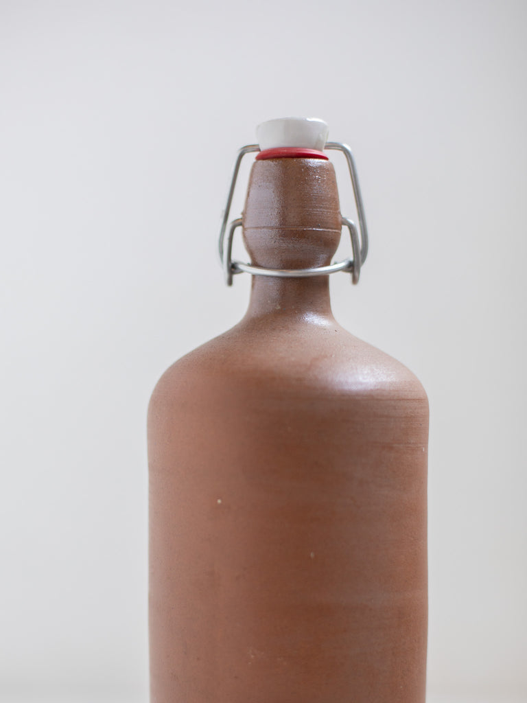 The bottle cap of a brown stone bottle. 